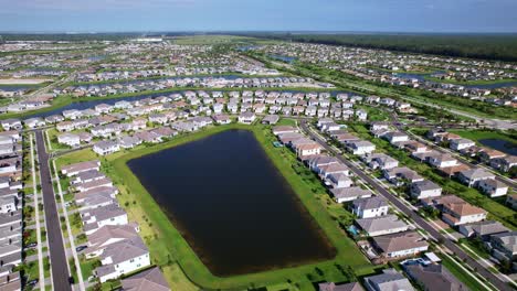 push in drone shot of residential area with homes and lakes during the day in west palm beach, florida, usa