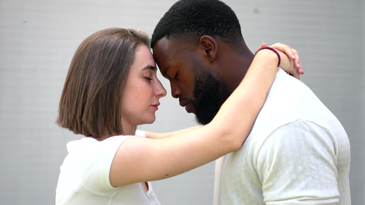 Interracial couple embracing intimately
