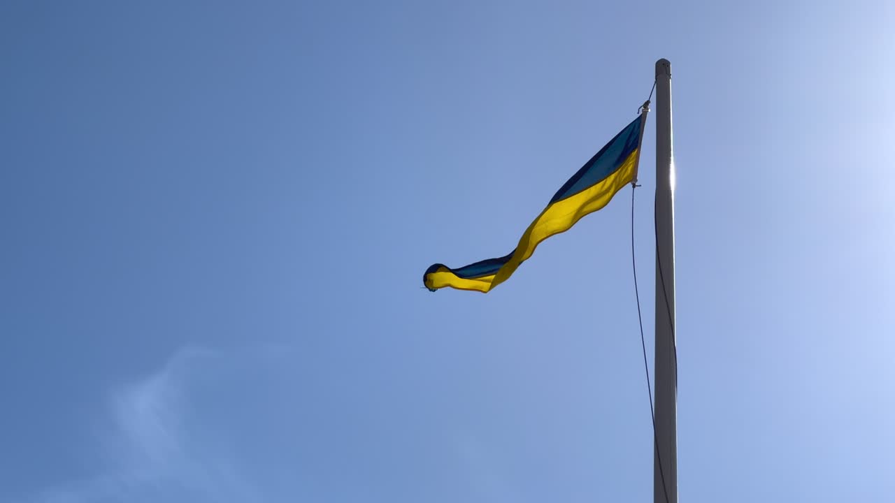 Swedish flag waving on pole on sunny summer day.