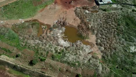 Aerial-top-down-shot-of-dirty-deleterious-water-pools-of-dumping-site-bordering-slums-area-district-in-Kibera,Kenya