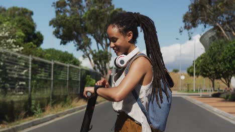 Mujer-Afroamericana-En-Scooter-Mirando-Smartwatch