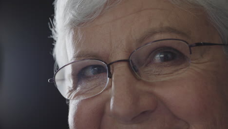 close up happy senior woman eyes looking at camera smiling happy enjoying healthy eyesight wearing glasses