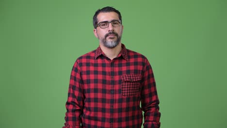 hombre persa guapo con barba y brazos cruzados.