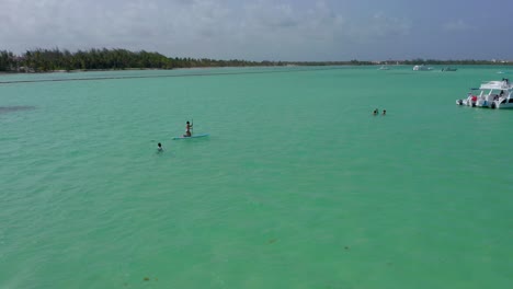 dando vueltas alrededor de la gente nadando y remando en increíbles aguas turquesas del océano, playa jaunillo, república dominicana