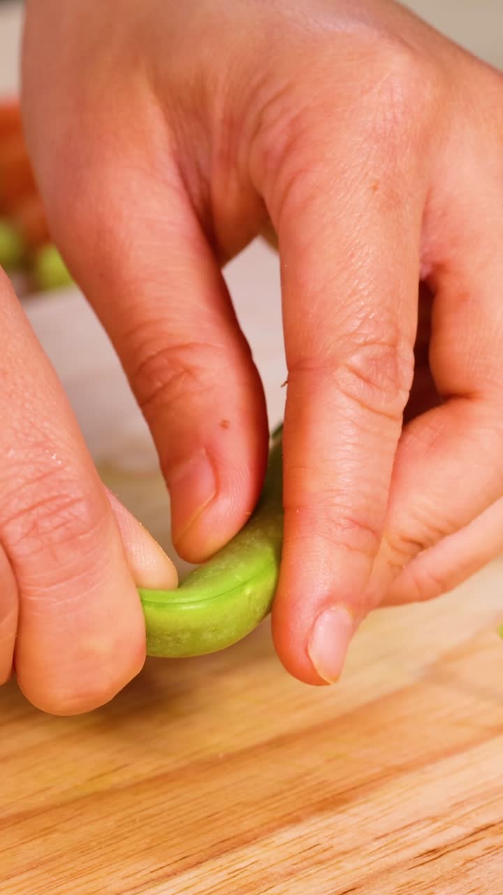 руки, обрушивающие горох на деревянную доску для резки