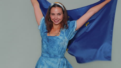 woman waving european union flag, smiling, cheering democratic laws, human rights freedoms in europe