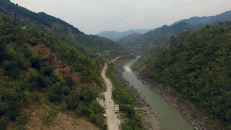 un aspecto veraniego de un río en las montañas que va maravillosamente con una carretera