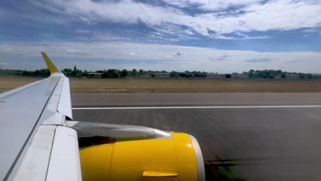 passenger point of view of yellow jet commercial airplane wing and engine during takeoff from london gatwick british airport in united kingdom