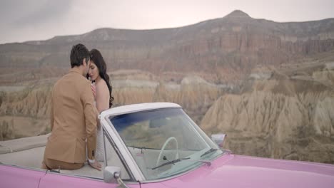 couple in a pink vintage car at scenic viewpoint