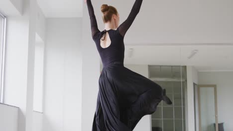 Caucasian-female-ballet-dancer-practicing-ballet-during-a-dance-class-in-a-bright-studio