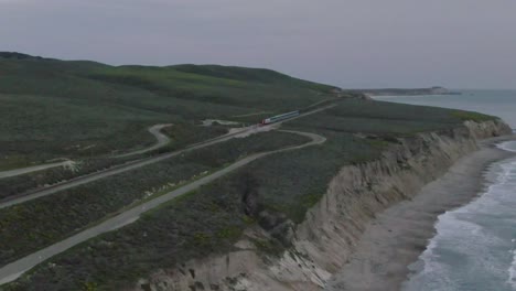 Tren-De-Pasajeros-De-Amtrak-Que-Se-Va-A-Lo-Largo-De-La-Costa,-A-Través-Del-Cruce-De-Carreteras