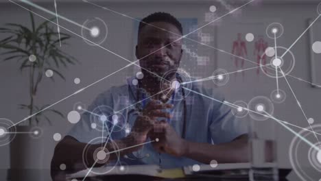 Animation-of-network-of-connections-and-dna-strand-over-african-american-male-doctor-talking