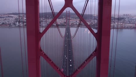 flying through pilar of ponte 25 de abril lisbon during sunrise, aerial