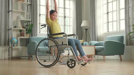 asian kid girl sitting in a wheelchair and stretching at home