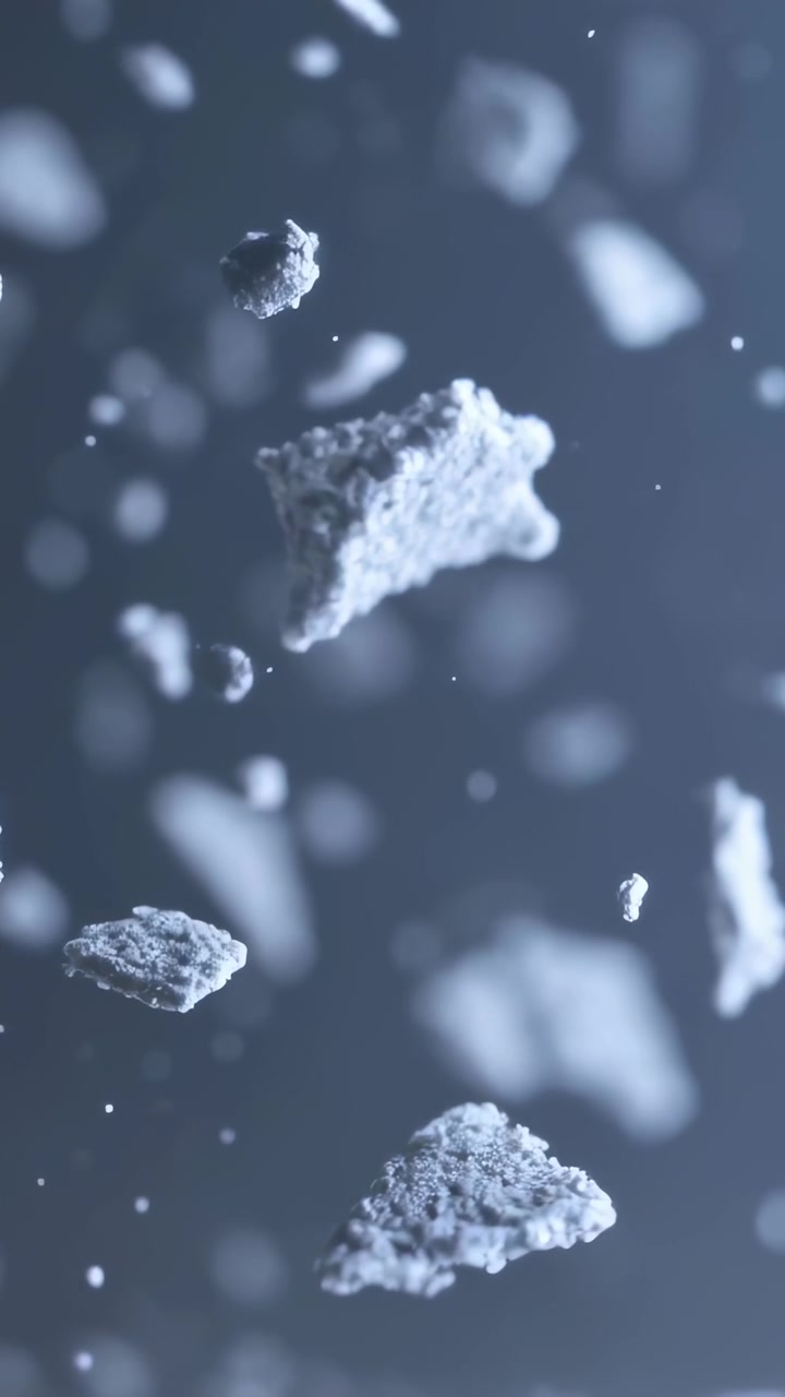 Video verticale: Una briciola a forma di piramide che inizia a ruotare verso il basso in uno studio macro, con polvere e pellet