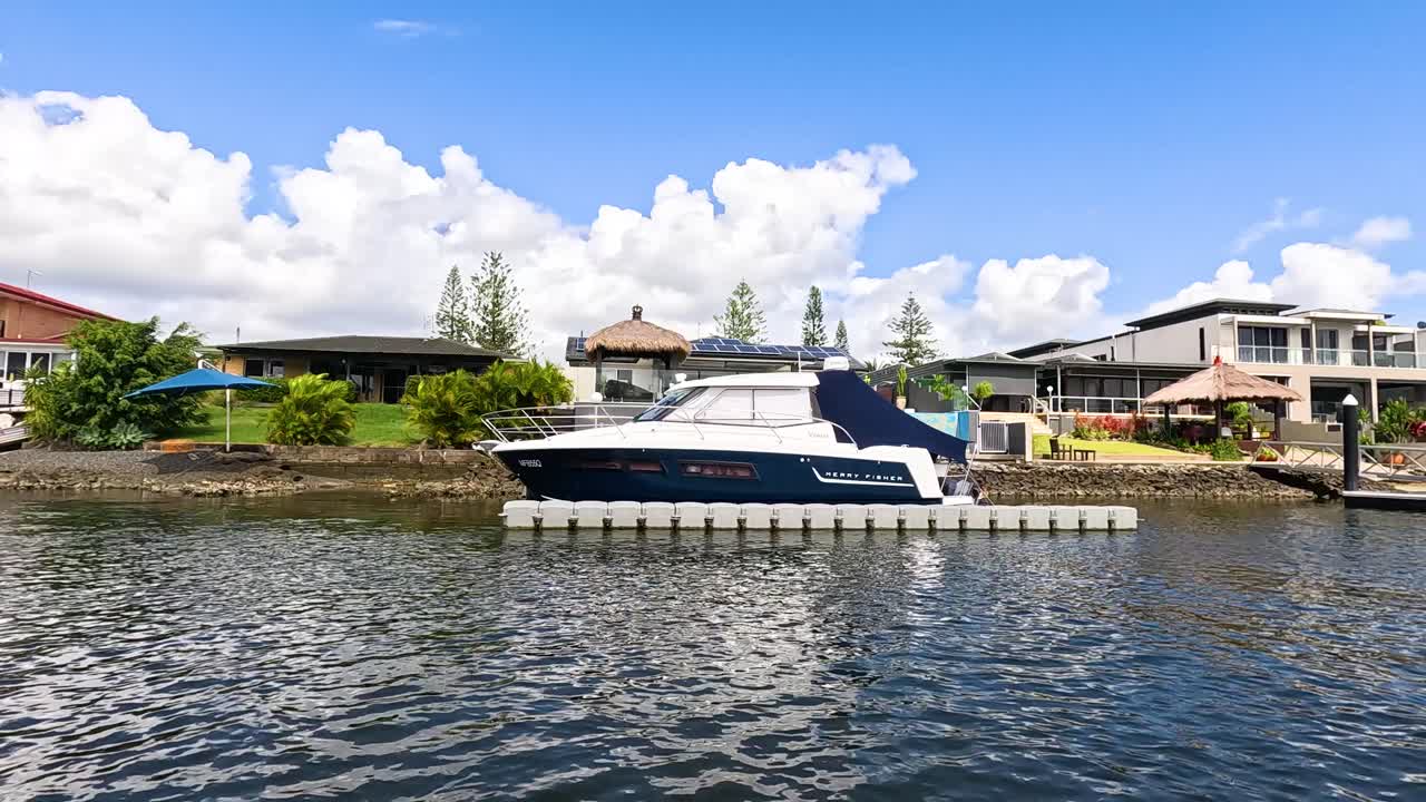Yacht in crociera davanti a case sul lungomare a Gold Coast