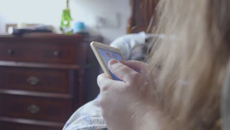 close up bored girl surfing online with the phone lying on the bed