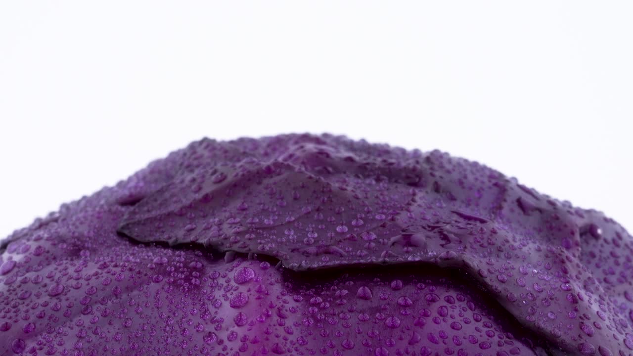 물방울을 가진 전체 미니 보라색 고추의 상단 부분의 매크로 촬영, 색 배경에 고립 된 회전 테이블에서 천천히 회전.