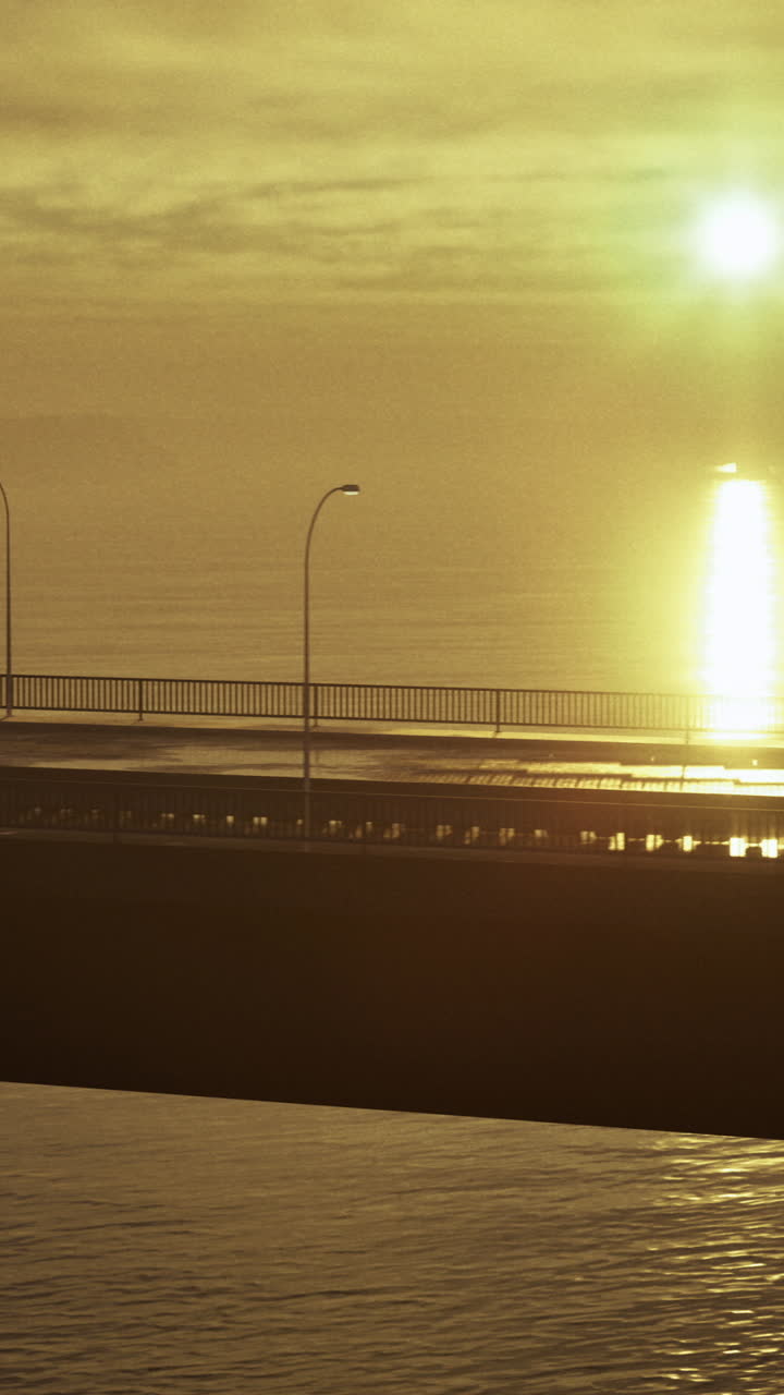 Sunrise casts golden hues over quiet bridge and calm water