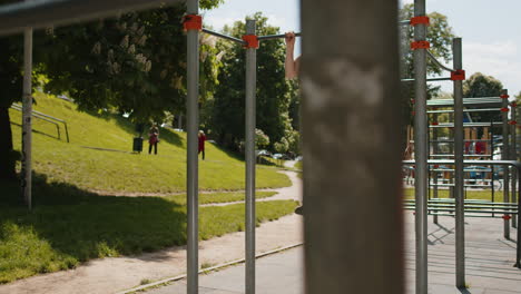 athletic man in sportswear doing pullups exercises on horizontal bar with help of elastic expander