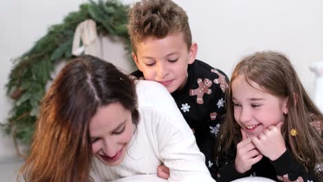 mom reads a fairy tale to children before bed on new years eve mom reads a fairy tale to children before bed on new years eve happy family on new years eve on the background of the christmas tree christmas comfort in the house