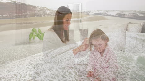 brushing child's hair, woman on serene beach with ocean waves in background