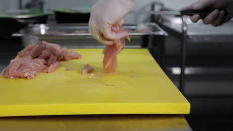 chef cortando pollo crudo en una cocina, 4k