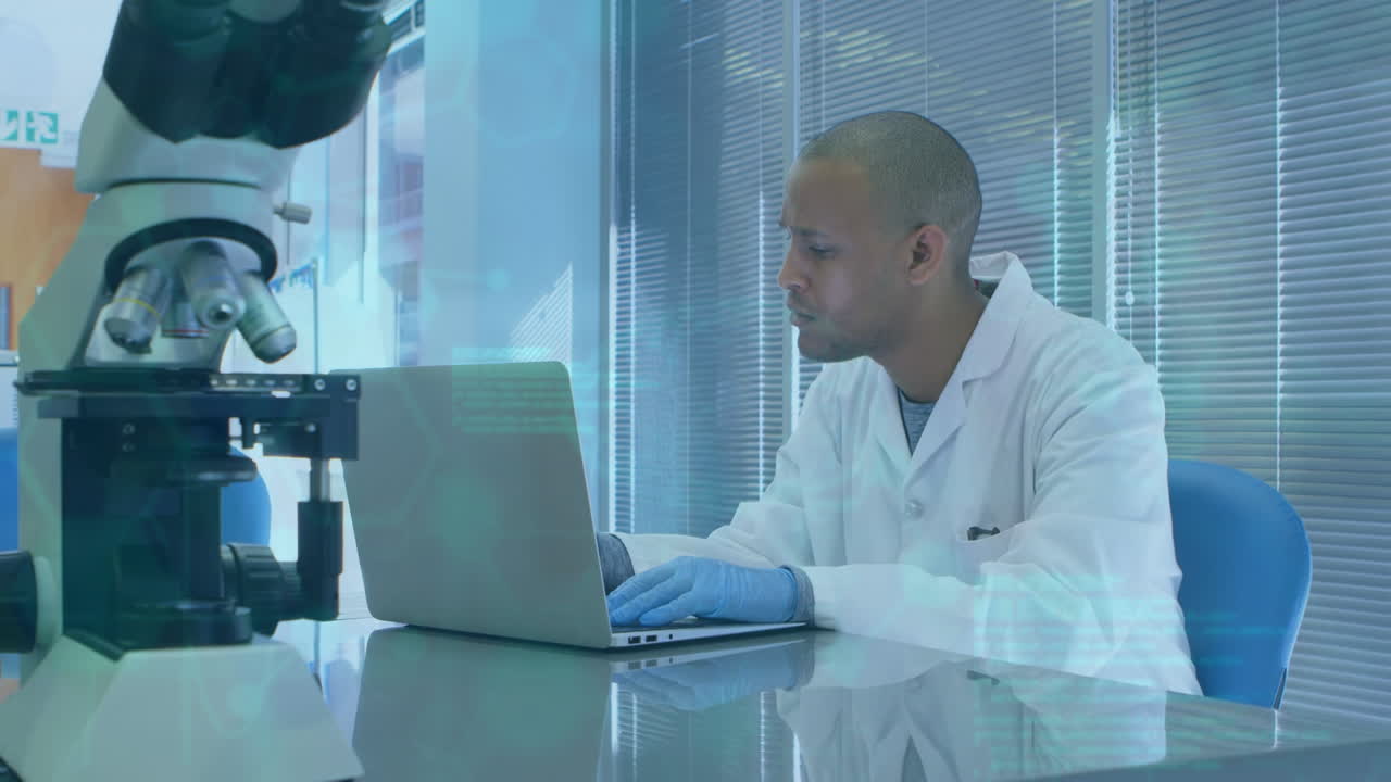 Animation of scientific data over african american male lab worker using laptop