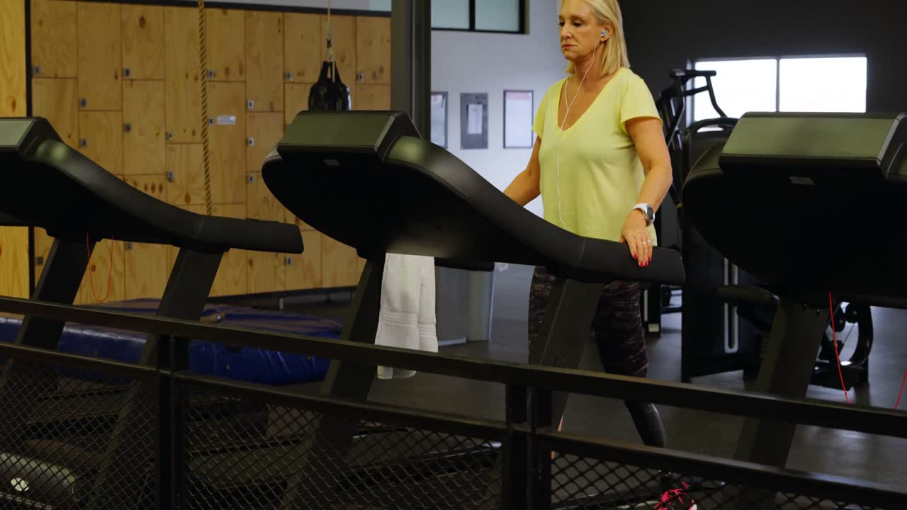 Donna che fa esercizio sul tapis roulant in palestra 4k