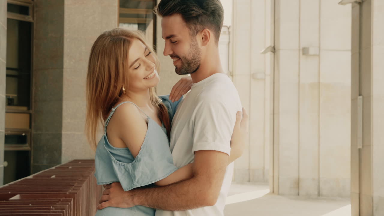 um casal feliz a abraçar-se ao ar livre.