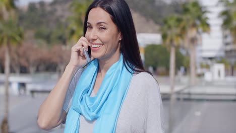 mujer entusiasta que usa el teléfono al aire libre