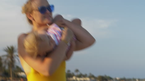 Mamá-Haciendo-Reír-A-Su-Hija,-Familia-Relajándose-En-La-Playa