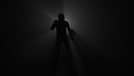 Silhouette-of-burglar-with-flashlight-and-bag