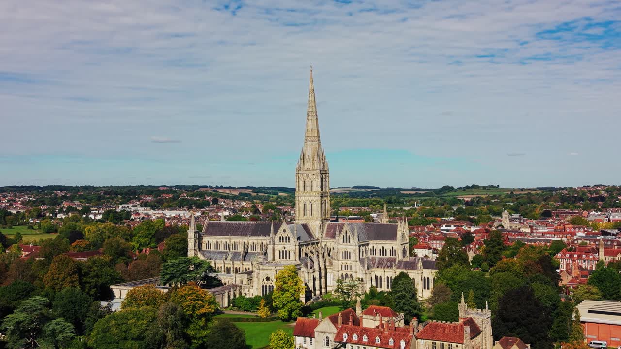 Droneudsigt fra luften over Salisbury Katedral, der rejser sig over den historiske by Salisbury i Wiltshire, England. Naturskøn udsigt over det berømte katedralspir omgivet af traditionel engelsk arkitektur og