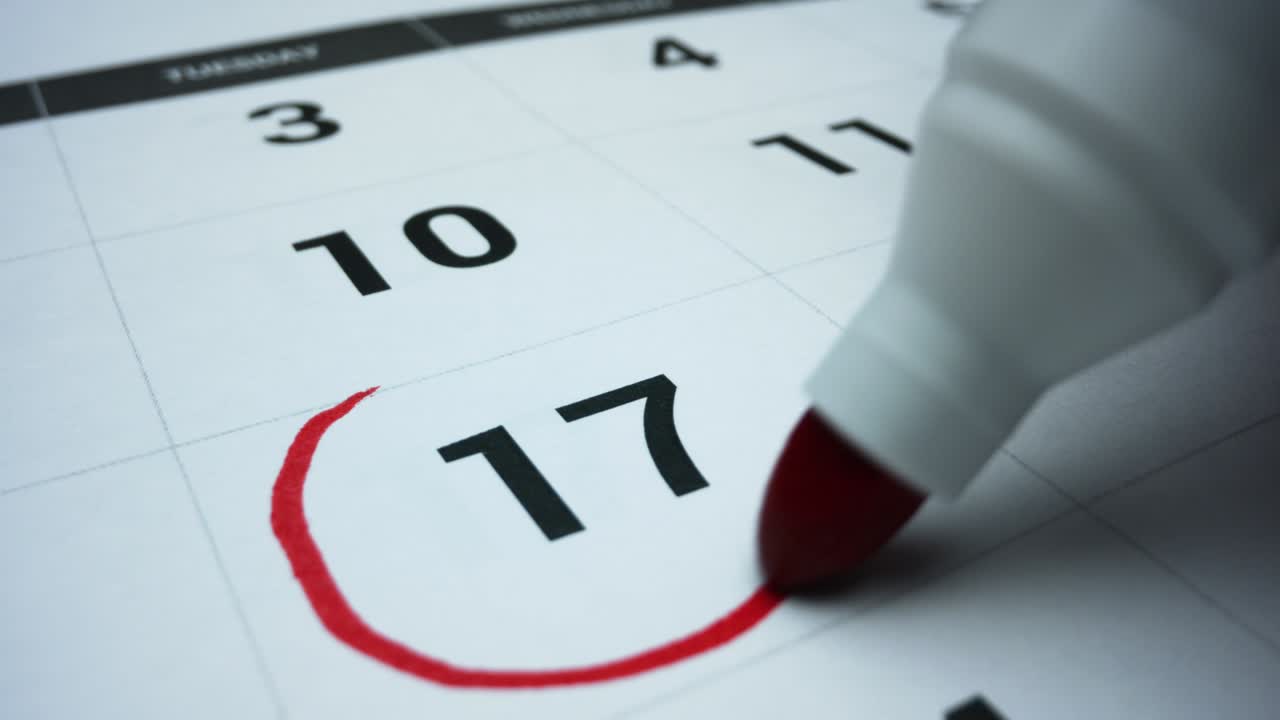 Business calendar for event planning. Female hand marking date on calendar