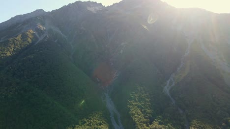 avalanche and meltwater river tracks on side of steep mountain at sunrise