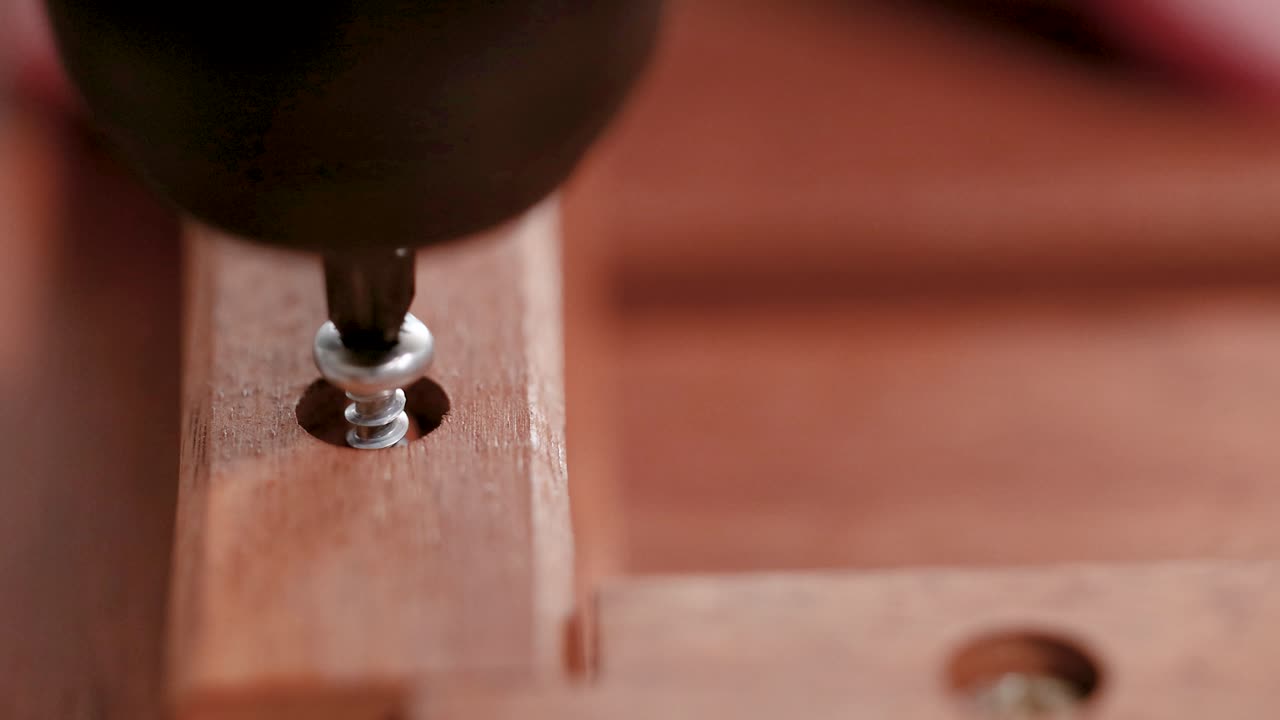 A sequence showing a screw being inserted into wood using an electric drill, highlighting precision and craftsmanship