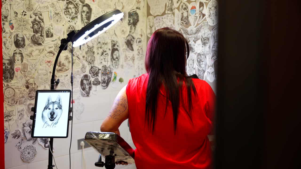 Zoom in shot of a woman waiting in the studio to have tattoo of her dog