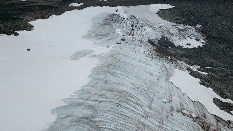 Tracking-shot-of-a-stony,-barren,-snow-covered-landscape-in-the-wilderness,-outdoor,-daylight,-no-people