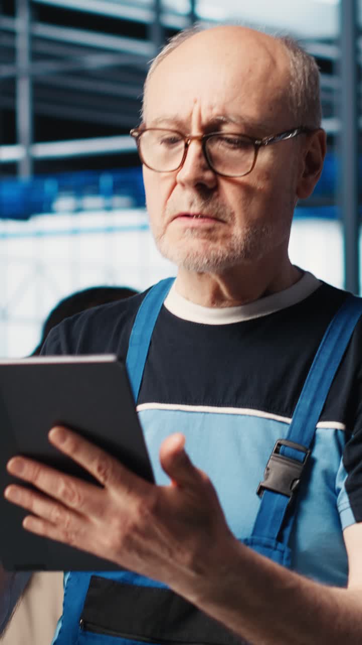 Vertikales Video: Leitender Ingenieur in Industrieanlage implementiert automatisierte Industrie 4.0-Arbeitsabläufe.