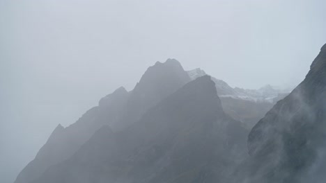 minimal rugged mountains background with copy space, minimalist dramatic mountain tops background with copyspace, moody atmospheric scene with misty low lying clouds