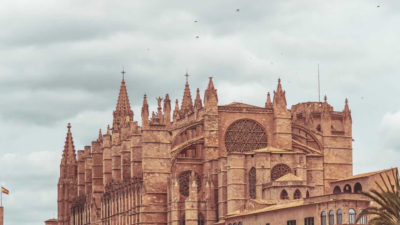 Timelapse of the La Seu Cathedral (Close-up to zoom out) in Palma, Mallorca, Spain. Gothic details of La Seu Cathedral under soft cloudy skies. Rose window and towers stand tall.