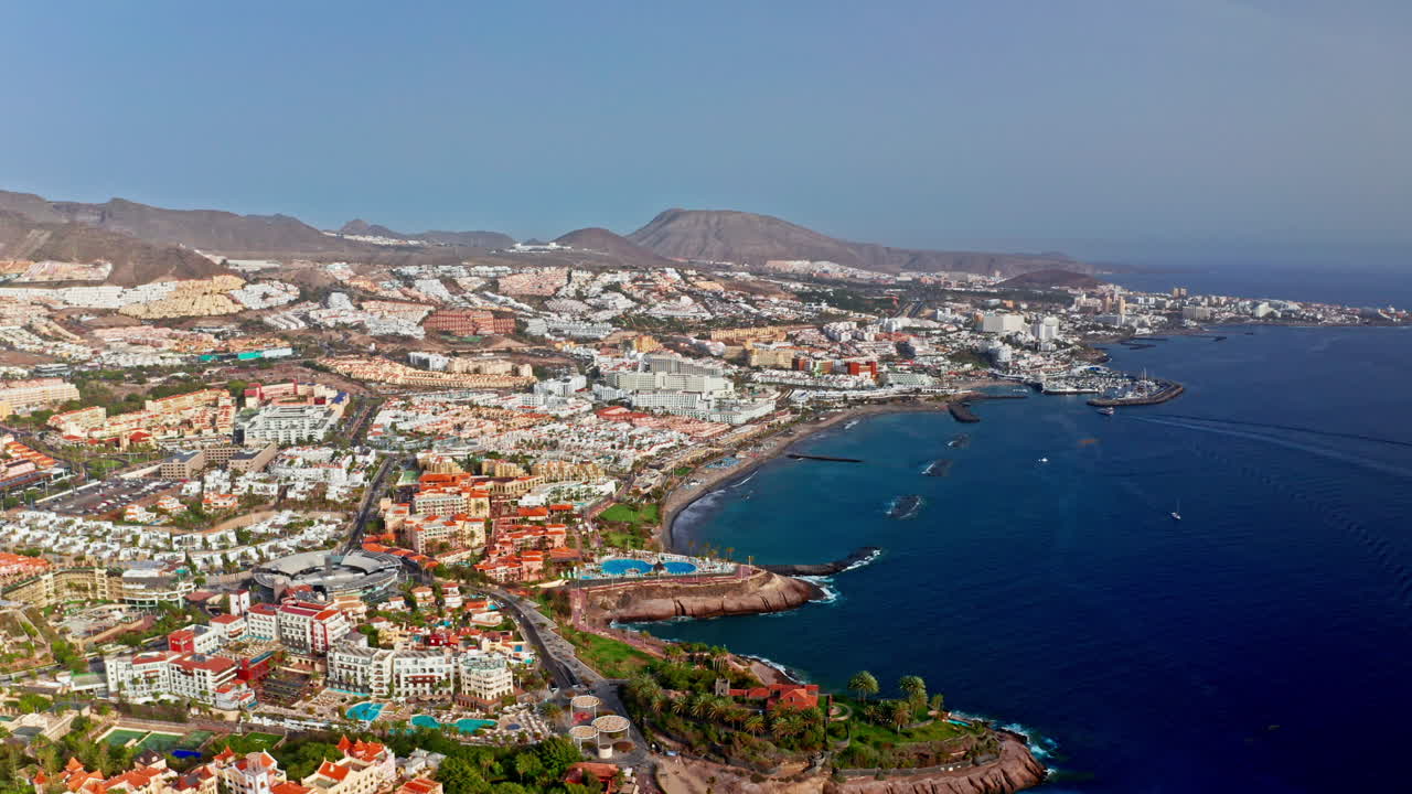 drone aéreo disparado sobre la hermosa costa rocosa volcánica de tenerife, islas canarias, españa. alta vista de los balnearios, el mar turquesa y las ciudades locales. destino de vacaciones de verano.