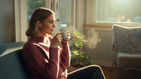 woman enjoying a hot drink in a sunlit living room