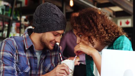 pareja bebiendo un batido juntos con paja en el pub
