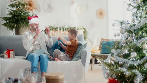 young boy and dad open christmas presents