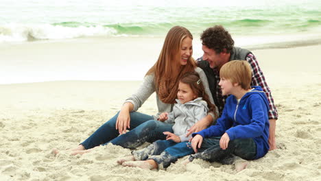 family sitting on the beach