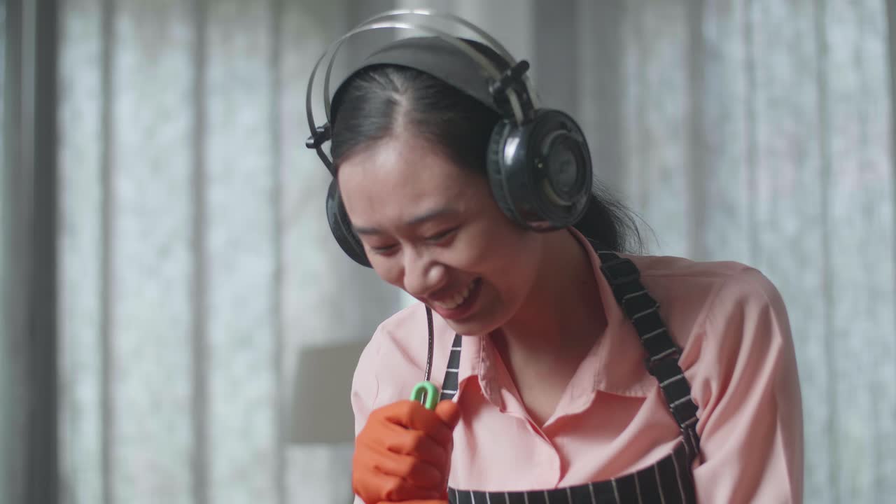 여자 청소 및 헤드폰으로 노래