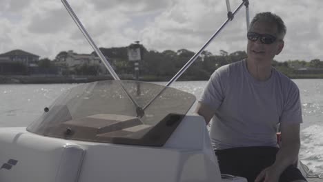 a man drives a boat along calm waters on a bright sunny day