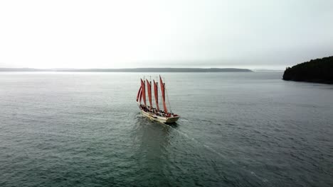 ship with four viking-style sails sailing on the water